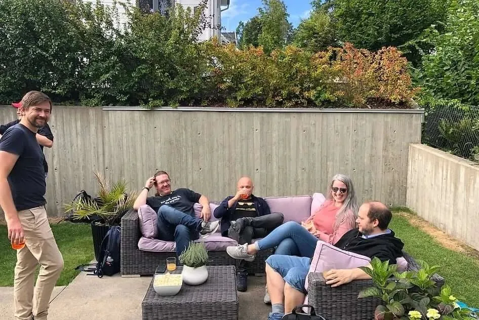 Colleagues relaxing together in the garden at a summer party